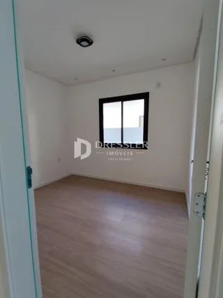 Vista interna de um corredor com piso de madeira clara.