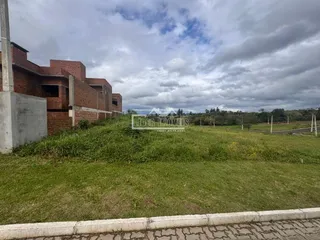 Fachada de uma residência com gramado e vegetação ao redor.