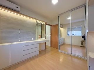 Ambiente interno moderno com piso de madeira clara e armários brancos.