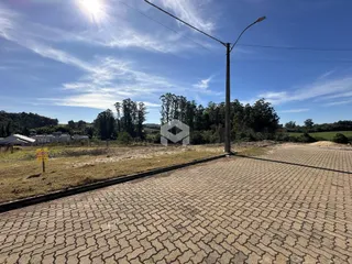 Vista da propriedade em Lajeado, Brasil, mostrando uma área pavimentada e vegetação.