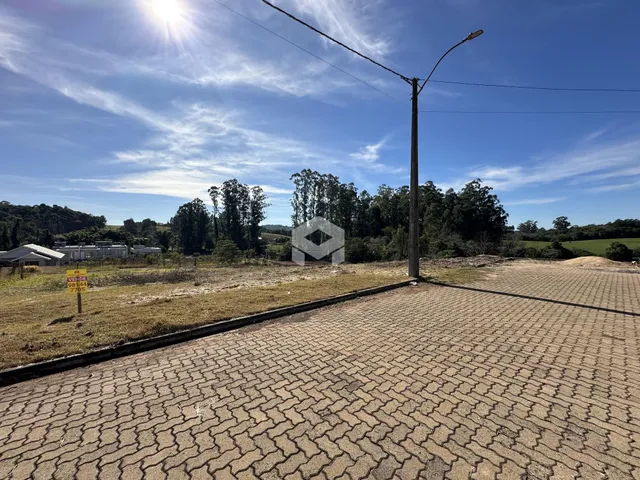 Vista da propriedade em Lajeado, Brasil, mostrando uma área pavimentada e vegetação.