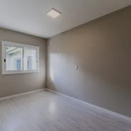 Foto de um cômodo interno com piso claro e parede lisa.
