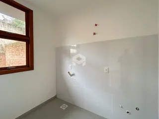 Vista interna de uma parede com janela e piso claro em uma residência.