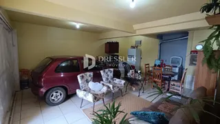 Sala de estar com um carro estacionado no interior de uma residência.