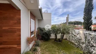 Fachada de uma residência com jardim gramado e cerca branca.