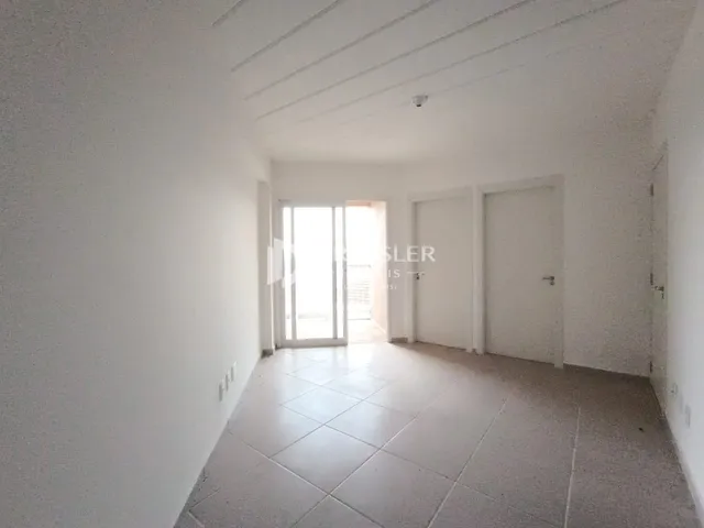 Corredor interno de uma residência com piso de cerâmica clara.