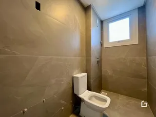 Foto de um banheiro com revestimento de pedra nas paredes.