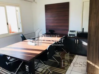 A mesa de jantar de madeira e a parede de destaque estão visíveis no ambiente.