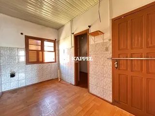 Uma sala de estar com piso de madeira e janela.