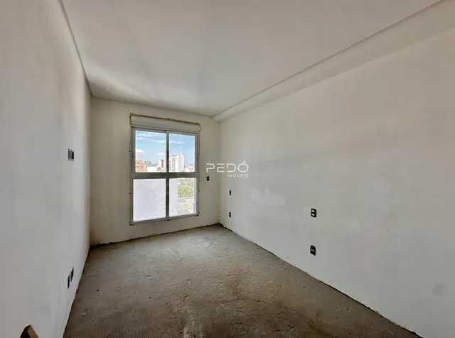 Ambiente interno vazio com paredes brancas e piso de concreto.