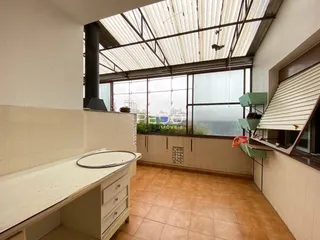 Interior de uma sala com piso de cerâmica e estrutura de telhado industrial.