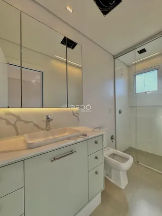 Foto de um banheiro moderno com bancada e armários brancos.