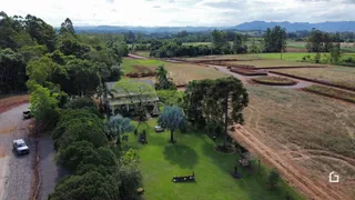 Vista aérea de uma propriedade rural com áreas de mata e campos.
