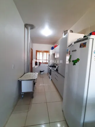 Hall de entrada com piso de cerâmica e geladeira visível.