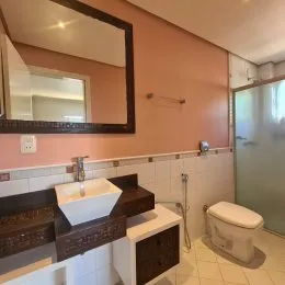 Foto de um banheiro interno com bancada e espelho.