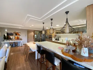 Sala de estar com piso de madeira e iluminação moderna.