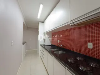 Vista da cozinha com armários brancos e revestimento vermelho