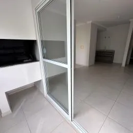 Vista interna de um corredor com portas de vidro e piso de cerâmica.