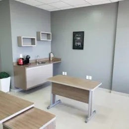 Sala de estar com um banco de madeira clara e paredes cinza na residência.
