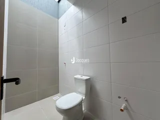 Interior de um banheiro com revestimento cerâmico branco.