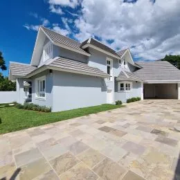 Foto da fachada de uma casa em Lajeado, Brasil, com telhado de telhas e área pavimentada.