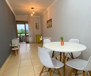 Ambiente interno de uma sala com piso de cerâmica e mesa redonda branca.