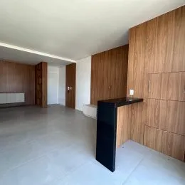 Vista interna de um ambiente com piso claro e painéis de madeira.