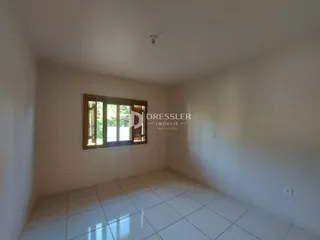 Ambiente interno com piso de cerâmica e janela de madeira.