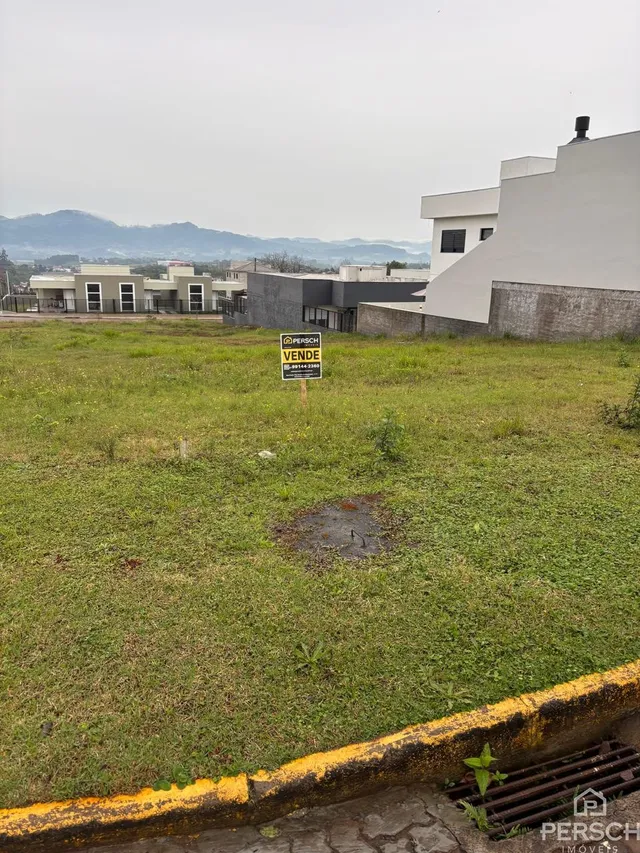 Vista externa de uma propriedade em Lajeado, Brasil, mostrando um terreno gramado em frente a um edifício branco.