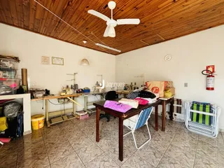 Ambiente interno de uma sala com teto de madeira e piso de cerâmica.