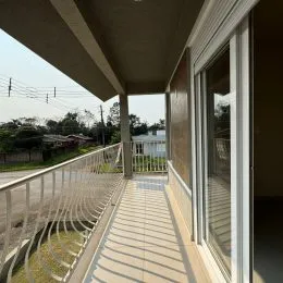 Vista externa de uma varanda com grade de proteção.