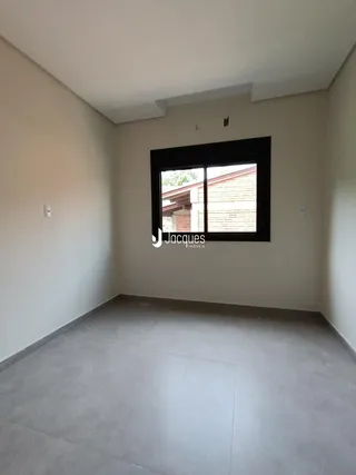 Esta é uma vista interna de uma sala com paredes brancas e piso de concreto.