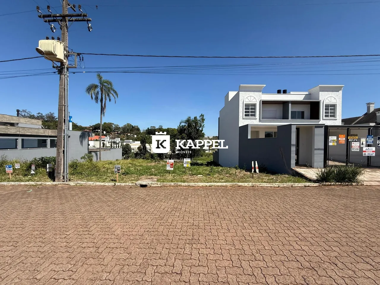 Fachada da casa branca em Lajeado, Brasil, com área externa em primeiro plano.