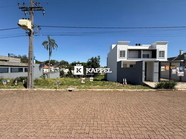Fachada da casa branca em Lajeado, Brasil, com área externa em primeiro plano.
