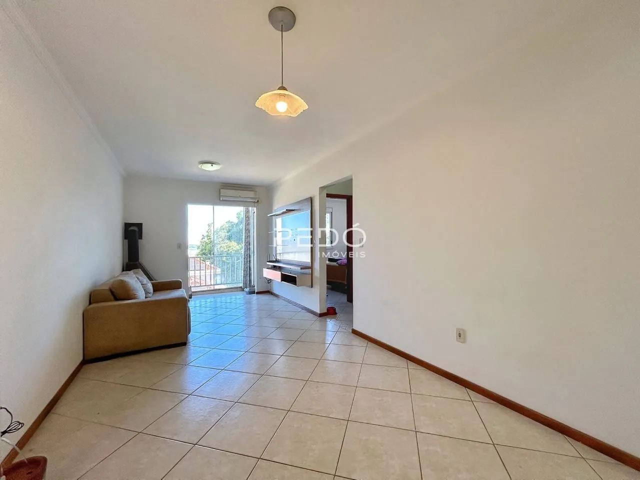 Sala de estar com piso de cerâmica clara e paredes brancas.