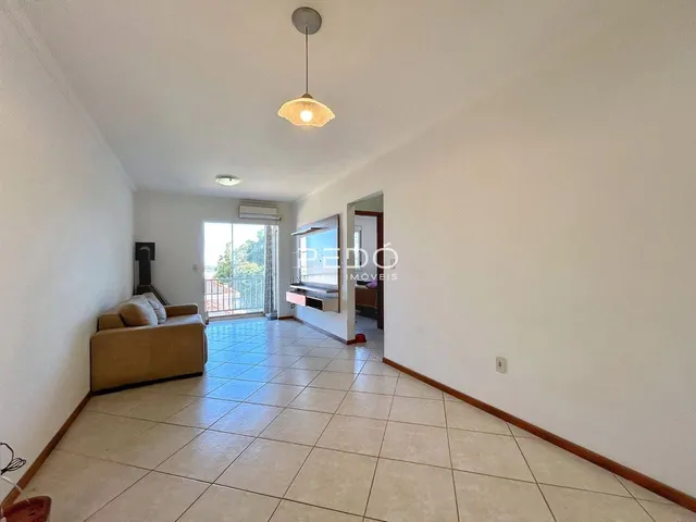 Sala de estar com piso de cerâmica clara e paredes brancas.