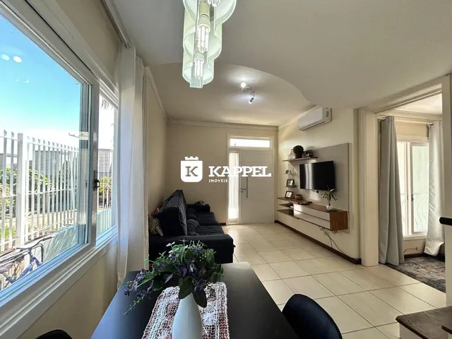Sala de estar com janela ampla e sofá escuro.