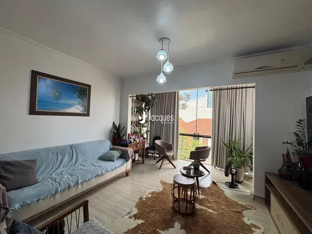 Sala de estar com sofá azul e piso de madeira clara.