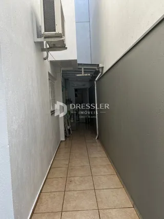 Corredor interno de um imóvel com piso de cerâmica e unidade de ar-condicionado.