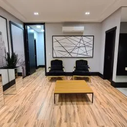 Sala de estar com piso de madeira e obra de arte na parede.