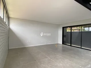 Vista interna de uma sala ampla com piso de cerâmica.