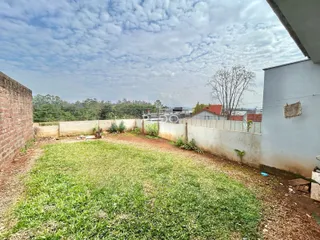 Foto da área externa de uma propriedade com gramado e muros.