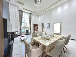 Sala de jantar espaçosa com mesa de jantar e decoração elegante.
