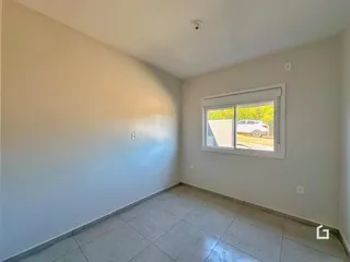 Foto de um cômodo interno com paredes brancas e piso de cerâmica.