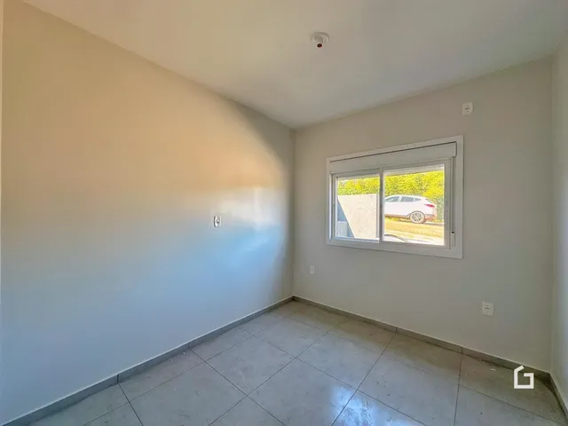 Foto de um cômodo interno com paredes brancas e piso de cerâmica.