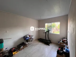 Uma sala de estar com paredes brancas e piso de cerâmica é mostrada na listagem.