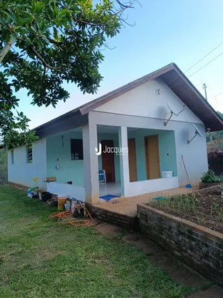 Fachada de uma casa em Lajeado, Brasil, com jardim e canteiro de flores na frente.