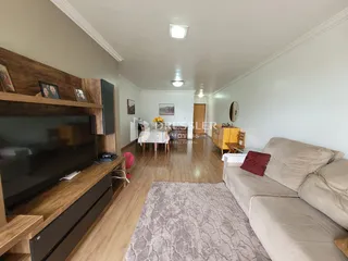 Sala de estar com sofá e painel de madeira na residência.