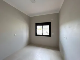 Vista interna de um ambiente com paredes brancas e piso claro.