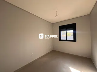 Foto de um ambiente interno com paredes claras e uma janela escura.
